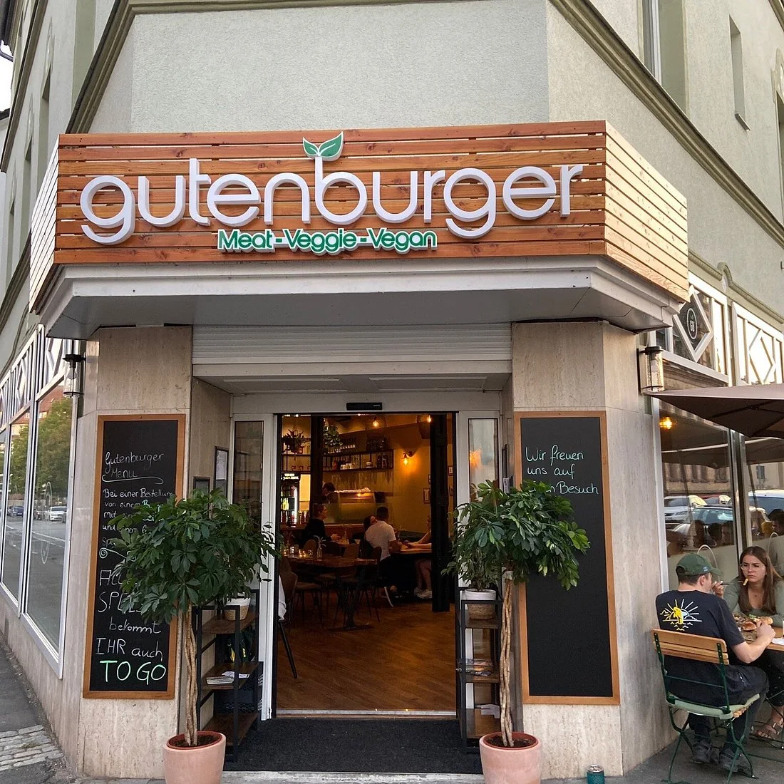 Gutenburger Restaurantfassade mit weißen 3D-Buchstaben auf einer Holzlamellen-Blende