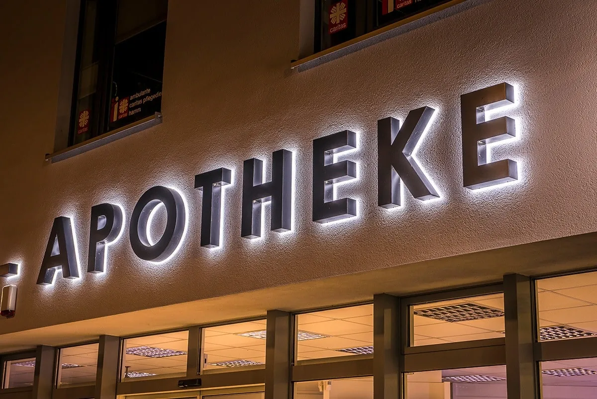 Beleuchtete Profilbuchstaben einer Apotheke an einer Fassade