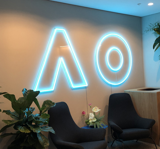 Große hellblaue Neon-Buchstaben AO in einem Loungebereich