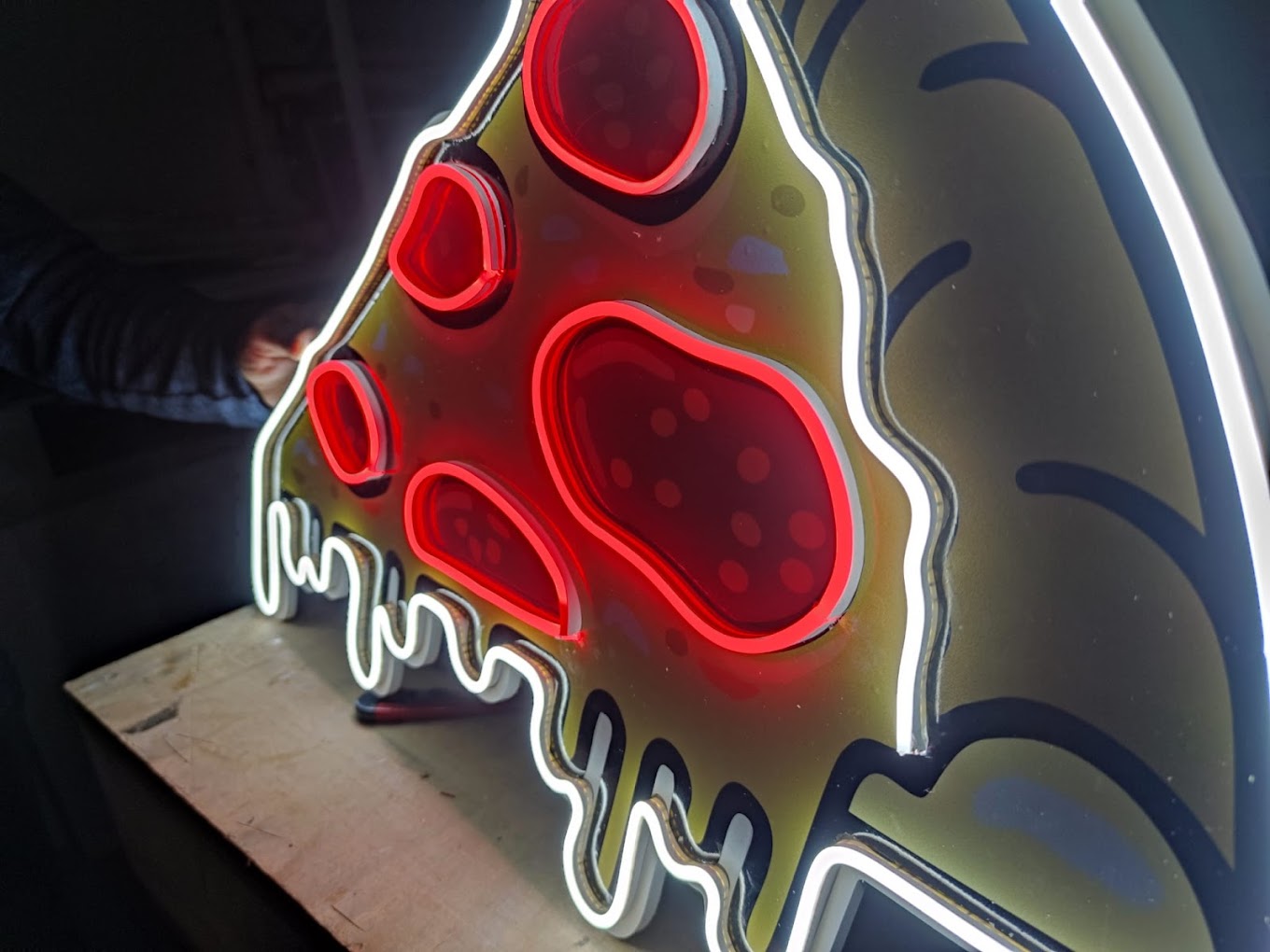 Detail eines individuell konturgefertigten roten und weißen Pizza-Neonschilds