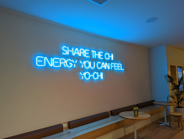 Blauer individueller Neon-Schriftzug an einer hellen Innenwand