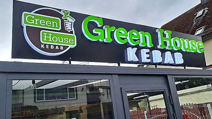 Realisierte Green House Fassadenwerbung mit dreidimensionalen Leuchtbuchstaben.