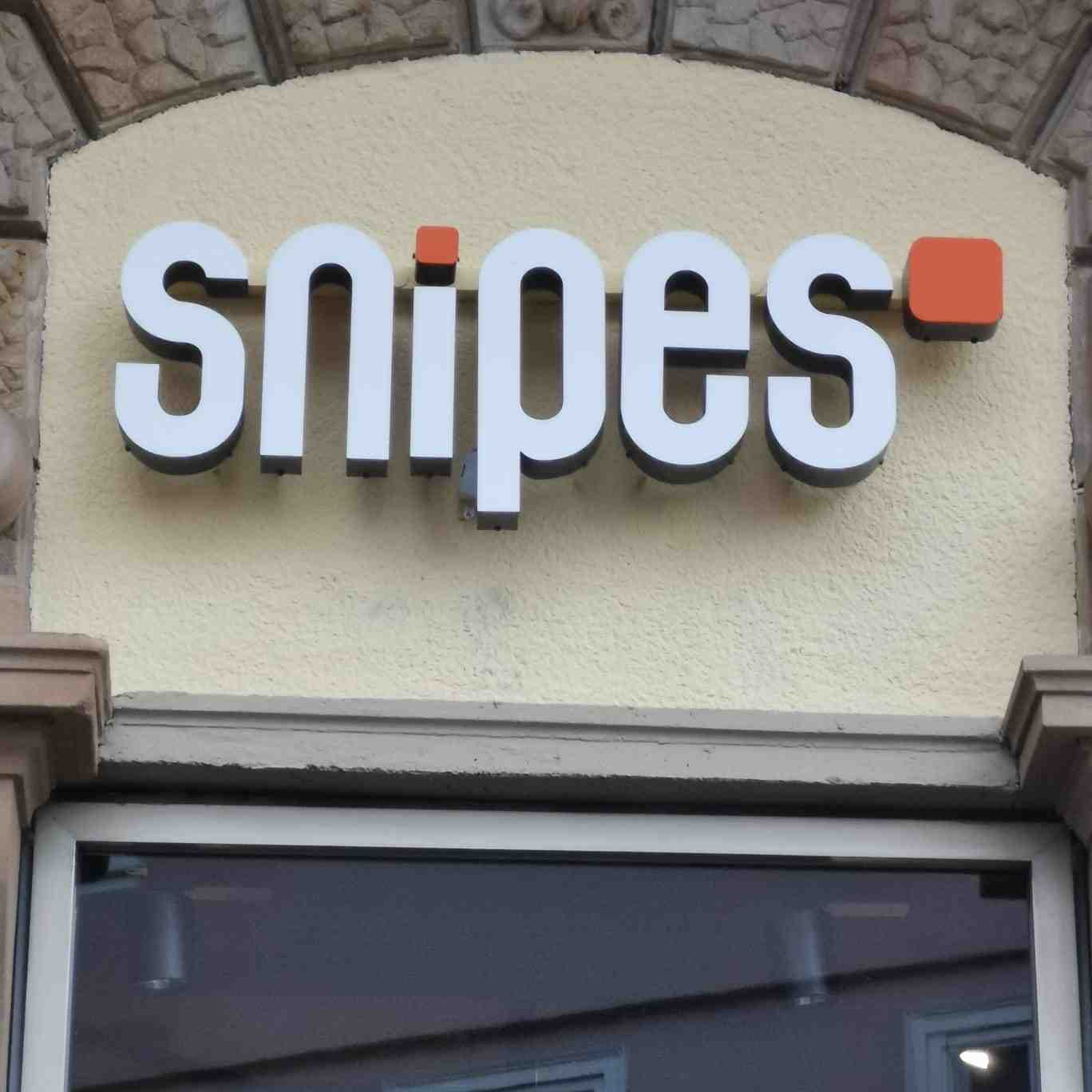 Weiße plastische snipes Einzelbuchstaben mit dunklen Seiten an einer hellen Fassade