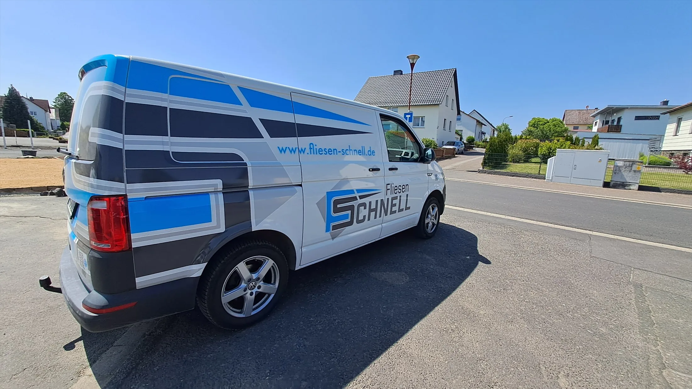 Blau und grau beschrifteter Transporter des Fliesenbetriebs Schnell